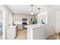 Modern kitchen featuring white cabinets, quartz countertops, and breakfast bar at 604 Foxwood Blvd, Englewood, FL 34223