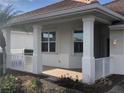 Covered front porch with white columns and tile flooring at 6379 Grand Cypress Blvd, North Port, FL 34287