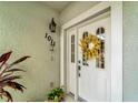 Inviting condo entry with a wreath and potted plants at 1000 San Lino Cir # 1011, Venice, FL 34292