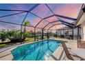 Relaxing screened-in pool area with patio furniture and sunset view at 1207 Highland Greens Dr, Venice, FL 34285