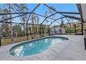 Refreshing pool with a screened enclosure, surrounded by ample patio space and lush greenery at 1230 Gantry Rd, North Port, FL 34288