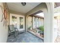 Covered entryway with terracotta tile flooring, featuring a sitting area and potted plants at 157 Angol St, Punta Gorda, FL 33983