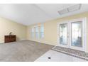 Bright and airy living room with carpeted floors, neutral walls, and French doors at 157 Angol St, Punta Gorda, FL 33983