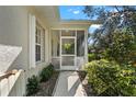 Screened porch entrance with walkway and lush green shrubs at 1577 Red Oak Ln, Port Charlotte, FL 33948