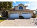 Two-car garage and inviting entryway with a brick paved driveway at 180 Hibiscus Dr # 112, Punta Gorda, FL 33950