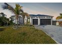 Beautiful two-story home with an attached garage and lush landscaping, showcasing its charming curb appeal at 183 Maria Ct, Punta Gorda, FL 33950