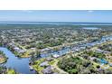 Aerial view of a waterfront community with canals, mature trees, and lush vegetation at 18390 Burkholder Cir, Port Charlotte, FL 33948