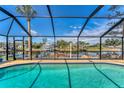 Screened in pool with a view of the canal, boat dock, and tropical landscaping at 18390 Burkholder Cir, Port Charlotte, FL 33948