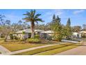 Single-story house with gray exterior, palm trees, and lush landscaping at 2202 Gold Oak Ln, Sarasota, FL 34232