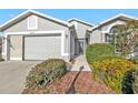 House exterior showcasing gray siding, a two-car garage, and manicured landscaping at 24117 Buckingham Way, Punta Gorda, FL 33980