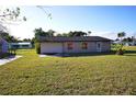 Back of the house showing a tan exterior and green lawn at 4200 Kilpatrick St, Port Charlotte, FL 33948