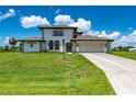 Two-story house with a beige exterior, two-car garage, and a landscaped lawn at 4630 Fallon Cir, Port Charlotte, FL 33948