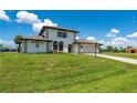 Two-story house with a beige exterior, two-car garage, and a well-maintained lawn at 4630 Fallon Cir, Port Charlotte, FL 33948