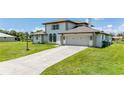 Two-story house with a beige exterior, two-car garage, and spacious driveway at 4630 Fallon Cir, Port Charlotte, FL 33948