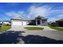 Modern home exterior with three-car garage and paver driveway at 490 Sorrento Ct, Punta Gorda, FL 33950