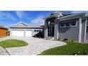 Modern home with gray siding, metal roof, and paver driveway at 490 Sorrento Ct, Punta Gorda, FL 33950