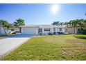 Front view of a single-story home with a well-manicured lawn at 525 Port Bendres Dr, Punta Gorda, FL 33950