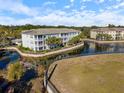 Aerial view showcasing condo building and tranquil lake setting at 700 Gardens Edge Dr # 722, Venice, FL 34285