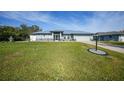 Single-story home with metal roof and spacious lawn at 7435 Snow Dr, Englewood, FL 34224