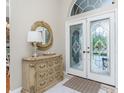 Elegant entryway with glass doors and ornate dresser at 1014 Francesca Ct, Punta Gorda, FL 33950
