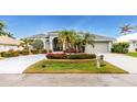 Single-story home features a lush, manicured lawn and palm trees at 1014 Francesca Ct, Punta Gorda, FL 33950