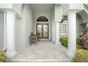 Covered front porch with tiled flooring, a bench, and columns at 1014 Francesca Ct, Punta Gorda, FL 33950