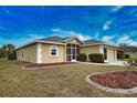 Tan house with gray roof, screened porch, and two-car garage at 110 Albatross Rd, Rotonda West, FL 33947
