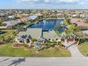 Aerial view of a waterfront home with a paved driveway and gorgeous landscaping in a quiet residential area at 1701 Casey Key Dr, Punta Gorda, FL 33950