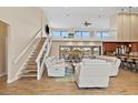 Open-concept living room featuring a staircase, large windows, and modern furnishings overlooking a waterfront patio at 1701 Casey Key Dr, Punta Gorda, FL 33950