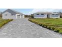 Long driveway leading to home featuring brick pavers, decorative landscape, and attached garage at 2154 Azure Rd, North Port, FL 34286