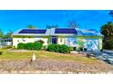 House exterior with solar panels, landscaping, and a garage at 22398 Walton Ave, Port Charlotte, FL 33952