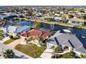 Lovely waterfront neighborhood with many canals; the home has a red roof, palm trees, and lush landscaping at 2240 Via Esplanade, Punta Gorda, FL 33950