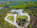 Waterfront property with an aerial view of a sprawling home, circle driveway, and lush surroundings at 27320 Egret Pl, Punta Gorda, FL 33983