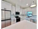 Bright kitchen featuring white cabinets, quartz countertops, stainless steel appliances, and modern black hardware at 2920 Barry Rd, North Port, FL 34286