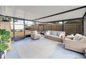Relaxing screened porch with wicker furniture and a view of the backyard at 325 San Benito Ave, North Port, FL 34287