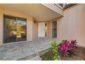 Inviting front porch with stone pavers, neutral tones, and pretty plants add curb appeal to this charming home at 5220 Landings Blvd # 104, Sarasota, FL 34231