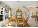 Dining room featuring a wooden table and chairs, tile floors, a chandelier, and large window at 1164 Harbor Town Way, Venice, FL 34292