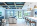 Open living space with high ceilings, modern decor, and sliding glass doors leading to backyard at 12717 Morning Mist Pl, Venice, FL 34293
