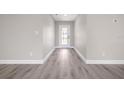 Hallway with elegant gray vinyl flooring and a door letting in ample natural light at 16031 Hesta Misty Ct, Punta Gorda, FL 33955