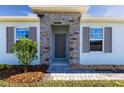 Inviting front entry with stone accents and gray front door at 16255 Lady Palm Dr, Port Charlotte, FL 33953
