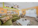 Bright living room with open floor plan, green couches and kitchen at 20 Medalist Cir, Rotonda West, FL 33947