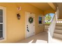 Charming condo entrance featuring unit number 113, a welcoming wreath, and well-lit access at 3329 Purple Martin Dr # 113, Punta Gorda, FL 33950
