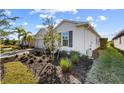 Landscaped yard with a white house exterior and a two car garage at 43104 Lakeside Way, Punta Gorda, FL 33982