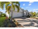 White house exterior, two-car garage, palm tree, and a brick driveway at 43104 Lakeside Way, Punta Gorda, FL 33982