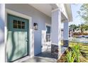 Quaint front porch with a teal door and stone columns at 706 W Madison St, Plant City, FL 33563