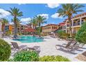 Resort-style pool with lounge chairs, tables, umbrellas, and tropical landscaping at 91 Vivante Blvd # 402/9142, Punta Gorda, FL 33950