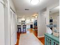 Inviting entry hallway leading to a kitchen with white cabinets, hardwood floors, and modern finishes at 1311 Abscott St, Port Charlotte, FL 33952