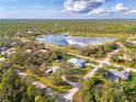 Beautiful aerial view of the home with a lake nearby amid lush greenery and neighborhood at 18181 Bly Ave, Port Charlotte, FL 33948