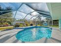 Gorgeous pool with a screen enclosure and a covered area featuring chairs for relaxation at 18181 Bly Ave, Port Charlotte, FL 33948