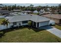 Well-maintained single-story home featuring a lush green lawn and attached two-car garage at 20431 Calder Ave, Port Charlotte, FL 33954